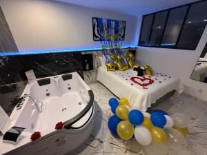 a room with a tub and balloons and a bed at Blāck diamond spa in Mulhouse