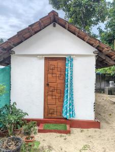 a small house with a wooden door at Marari Red Angel in Mararikulam