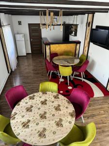 a dining room with a table and colorful chairs at Casa Ilinca Bran in Şimon
