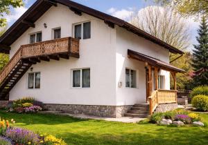 a large white house with a wooden balcony at Casa Ilinca Bran in Şimon