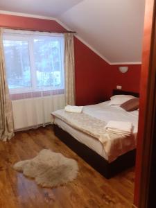 a bedroom with a bed and a window and a rug at Casa Ilinca Bran in Şimon