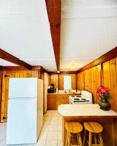 a kitchen with a white refrigerator and wooden walls at Rock Castle Resort in Lake George +28 photos