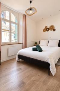 a bedroom with a large bed and a large window at Calme et confort au cœur du vieux Troyes in Troyes