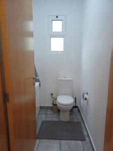a bathroom with a toilet in a white room at Madeira Pura in Calheta +6 photos