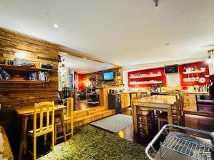 a kitchen with wooden walls and tables and yellow chairs at Treehouse Patagonia in Puerto Natales +15 photos