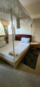 a bedroom with a canopy bed and a table at Tarakea Lodge in Mbuguni