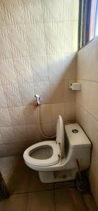 a small bathroom with a toilet and a window at Tarakea Lodge in Mbuguni
