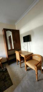 a room with a table and chairs and a television at Tarakea Lodge in Mbuguni