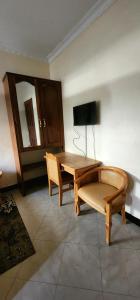 a living room with a wooden table and a chair at Tarakea Lodge in Mbuguni +9 photos