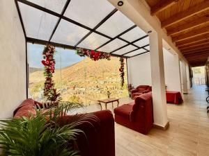 a living room with red couches and a large window at Hotel Nuevo Amanecer in Real de Catorce