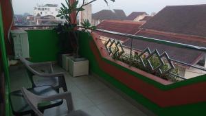 a balcony with two chairs and a green wall at The Cabin Hotel Ngupasan in Yogyakarta