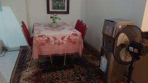 a dining room table with a pink table cloth and a fan at The Cabin Hotel Ngupasan in Yogyakarta