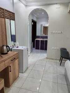 a kitchen with white tile flooring and an archway at شقق مفروشة مكين 1 in Medina