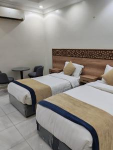 a hotel room with two beds and a table at شقق مفروشة مكين 1 in Medina