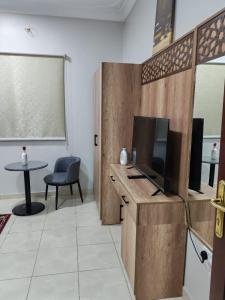 a room with a desk with a tv and a table at شقق مفروشة مكين 1 in Medina