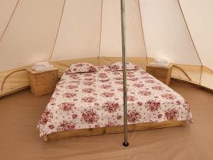 a bed in a tent in a room at CampingSiriu in Caşoca