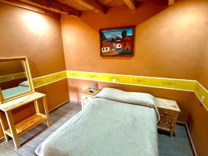 a bedroom with a bed and a painting on the wall at Hotel Nuevo Amanecer in Real de Catorce +7 photos