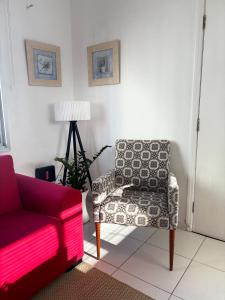 a living room with a couch and a chair at Espaço Zen - Equilíbrio da Alma in Guarujá