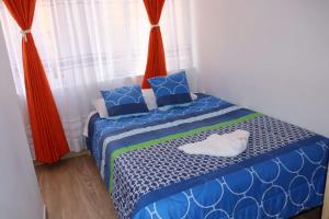 a bedroom with a bed with blue and white sheets at Hotel Inkanta in Ipiales +2 photos