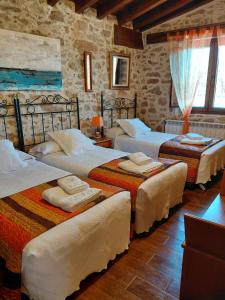 a bedroom with three beds in a room at CASA RURAL SANDRA in La Carrera