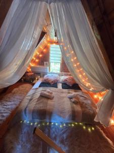 a bedroom with a canopy bed with lights at Napsugár Kakasvár in Orosháza