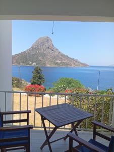 a picnic table on a balcony with a view of the ocean at Sevi - Irene Studios in Masouri +10 photos