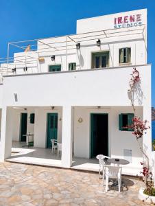 a white house with a patio and a table at Sevi - Irene Studios in Masouri