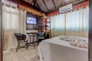 a bedroom with a bed and a table and chairs at Aldeia da Mata Ecolodge in Serra Grande