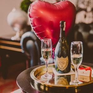 a bottle of champagne and two glasses on a table with a heart at Apartament Wiejska 5a in Ciechocinek