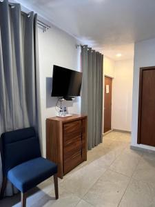 a living room with a tv and a chair at Hotel Rinconda del Arcangel in Tepoztlán