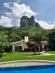a house with a mountain in the background at Hotel Rinconda del Arcangel in Tepoztlán