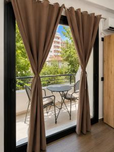 a balcony with a table and chairs and a window at Lungomare private rooms in Vlorë