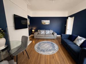 a living room with a couch and a glass table at Queenie's Nook in North Shields