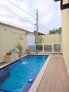 a swimming pool with a fountain in a house at Anexo da Paz Tucuns Búzios in Búzios