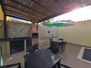 a patio with a table and chairs and an umbrella at Anexo da Paz Tucuns Búzios in Búzios