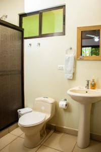 a bathroom with a toilet and a sink at Hotel D'Lucia - Quebrada Ganado, Jaco, Costa Rica in Puntarenas +21 photos