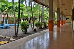 an empty hallway with palm trees in a building at Hotel D'Lucia - Quebrada Ganado, Jaco, Costa Rica in Puntarenas