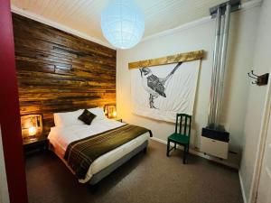 a bedroom with a bed and a wooden wall at Treehouse Patagonia in Puerto Natales