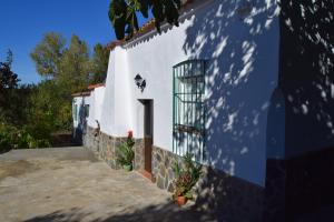 a white building with a door and a window at Casa Rural Parajes del Chanza in Cortegana