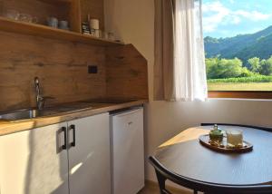 a kitchen with a table and a sink and a window at Kućica na jezeru in Jezero +13 photos