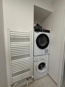 a microwave and a washing machine in a room at Une petite chambre jardin in Dijon