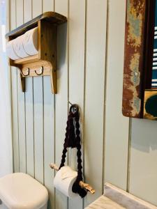 a bathroom with a toilet and a shelf with towels at Treehouse Patagonia in Puerto Natales