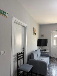 a living room with a chair and a couch and a tv at Rezidenca Inspire in Tirana
