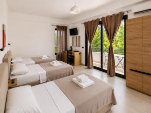 a hotel room with two beds and a balcony at Lungomare private rooms in Vlorë