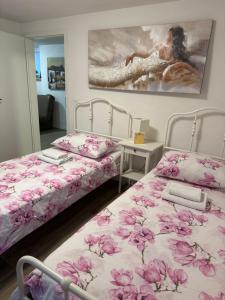 two beds in a room with pink flowers on them at Turistična kmetija Birsa in Dobravlje +45 photos