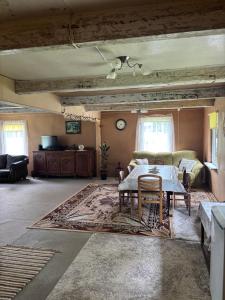a living room with a table and a couch at Stovyklavietė Dauba in Šyliai