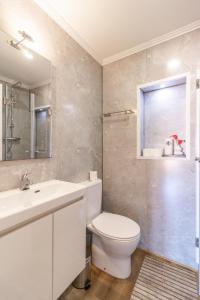 a bathroom with a white toilet and a sink at Alma do Bairro in Lisbon +113 photos