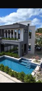 a large house with a swimming pool in front of it at Casa Aquiraz in Aquiraz