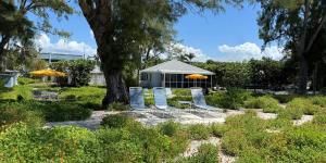 a garden with chairs and umbrellas in front of a building at Bamboo Apartments in Holmes Beach