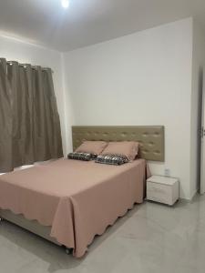 a bedroom with a bed with two pillows on it at Casa Aquiraz in Aquiraz +22 photos